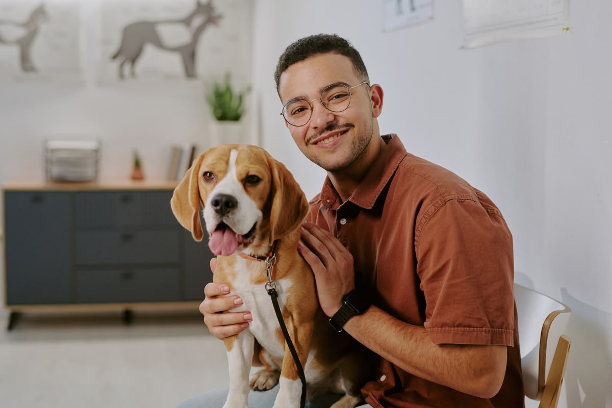 A person happily petting their emotional support dog on a couch, illustrating housing stability with an ESA letter.